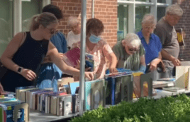 Customers shop the Friends Summer Book Sale outside